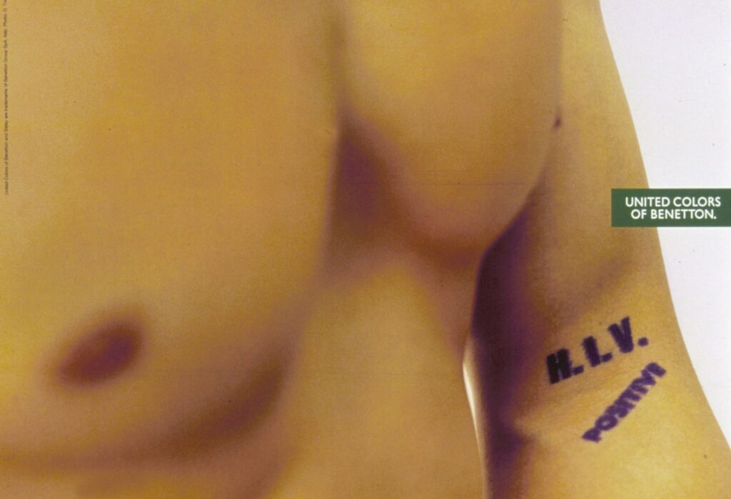 Die Benetton-Werbung mit dem durchtrainierten weißen Mann und dem tätowierten Schriftzug „HIV POSITIVE“ wurde 1993 von Oliviero Toscani inszeniert, um HIV-Positive aus der Opferrolle zu holen, mit Stereotypen zu brechen und das Stigma rund um Aids offensiv zu hinterfragen – kraftvoll, provozierend und bewusst unbequem.
Bild: Benetton-Group