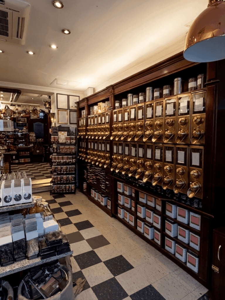 Kaffee und edle Röstwaren werden in diesem eleganten Fachgeschäft aus glänzenden Schütten und dekorativen Regalen angeboten (Bild KI-optimiert).