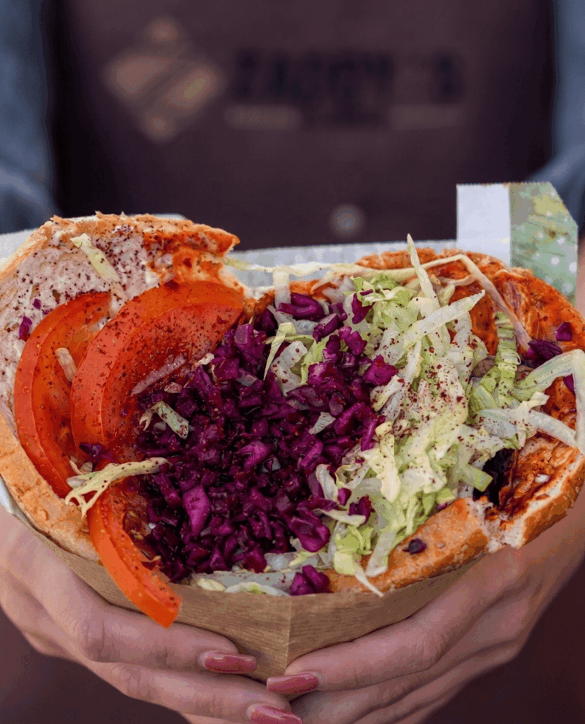 Dieses goldbraun gebackene, herzförmige Fladenbrot offenbart eine leidenschaftliche Komposition aus würzigem, kross gebratenem Fleisch, knackig-frischem Gemüse und einem Herzstück aus zartem, weißem Käse, das wie eine kulinarische Liebeserklärung an den Gaumen wirkt. (Bild: Instagram, KI-optimiert.)