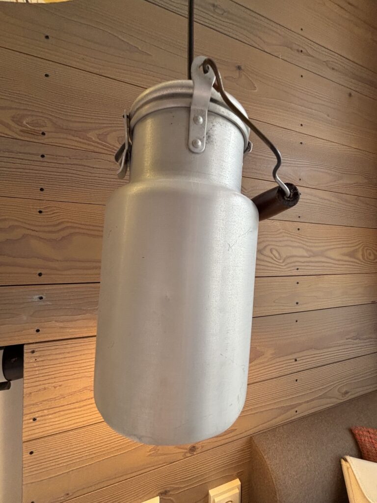 Gelungenes Interior-Design im Cocoon München: Eine klassische Milchkanne wird über dem Nachttisch zum leuchtenden Statement-Piece.